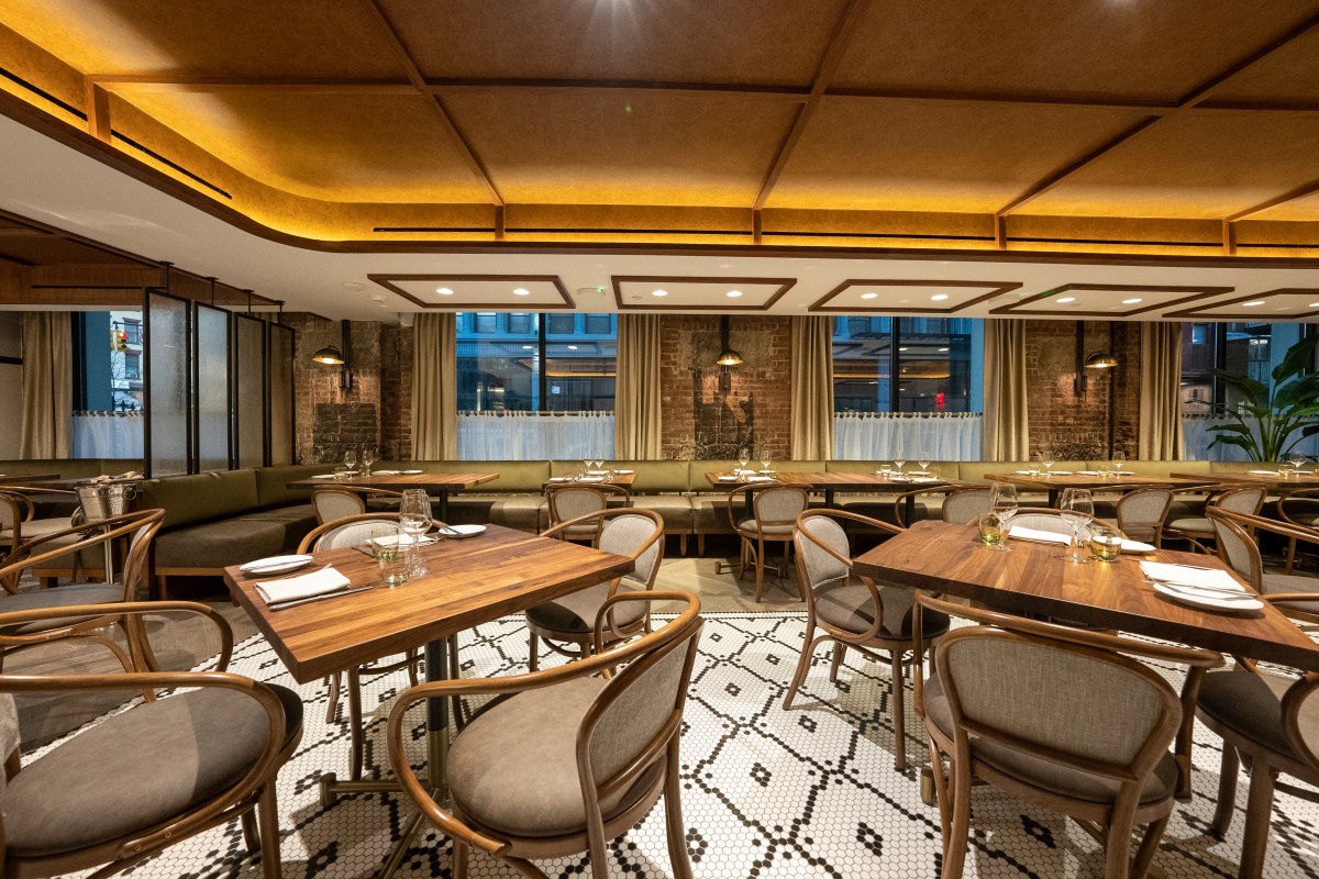 Francie dining room with wood tables, mosaic tile floor, brick walls and warm lighting