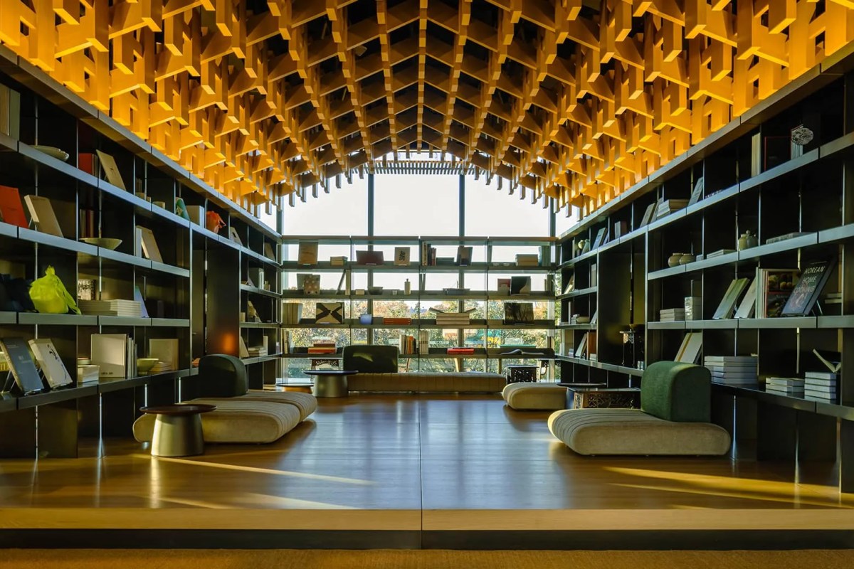 Interior lounge space with soaring wooden lattice ceiling and bookshelves lining walls