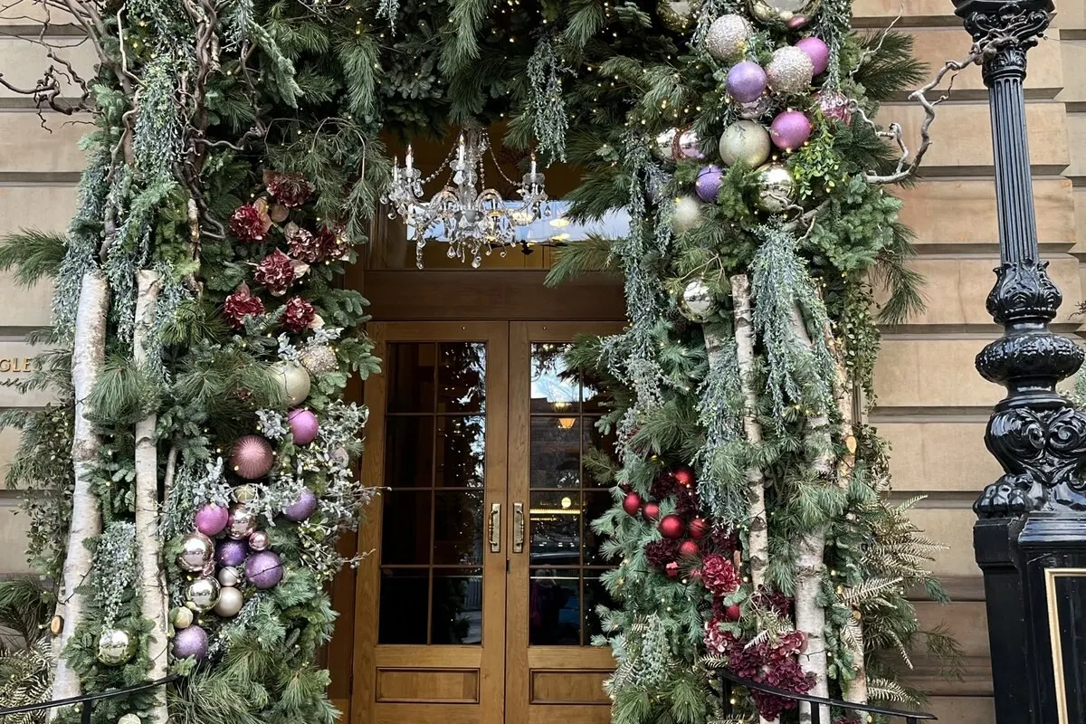 Entrance doorway of Gleneagles Townhouse Edinburgh framed by festive Christmas garlands and ornaments on stone façade