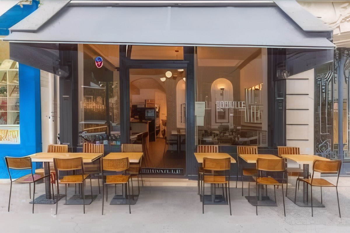 Restaurant exterior with awning, terrace tables and chairs, Godaille sign visible through window
