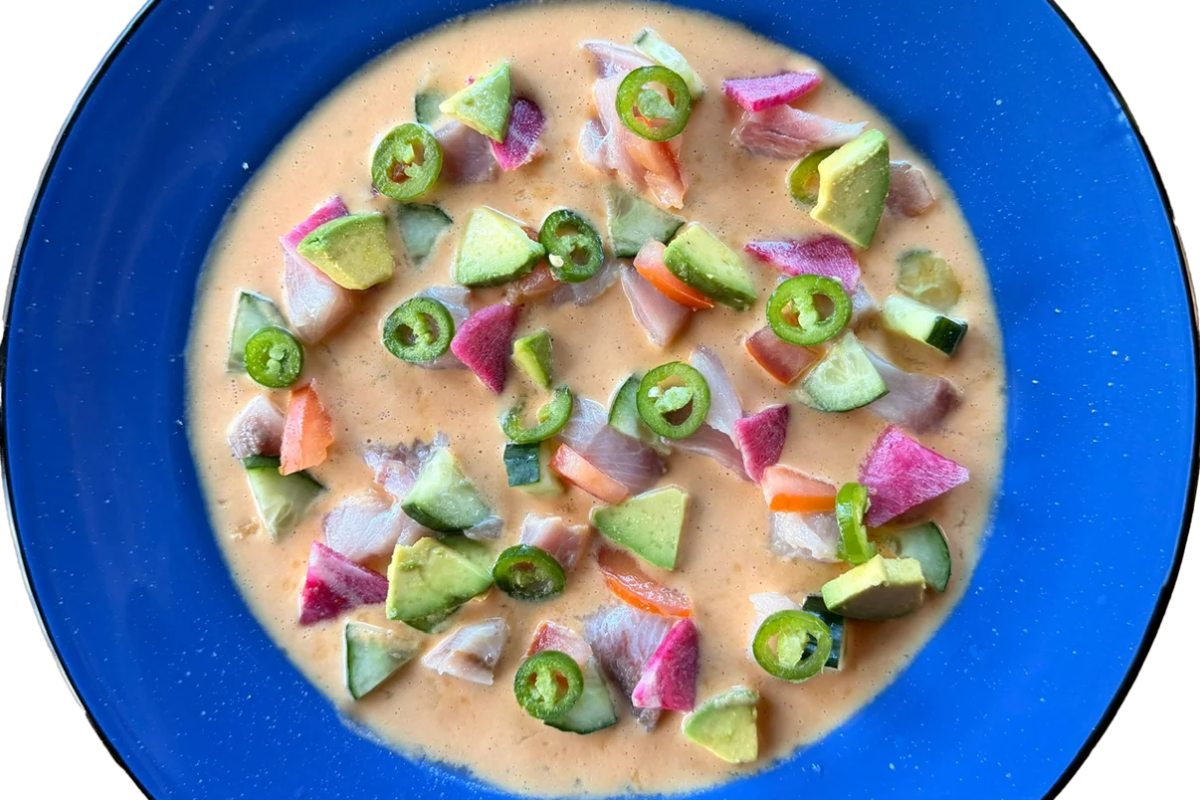 Ceviche with avocado, radish, jalapeño and citrus on a blue enamel plate