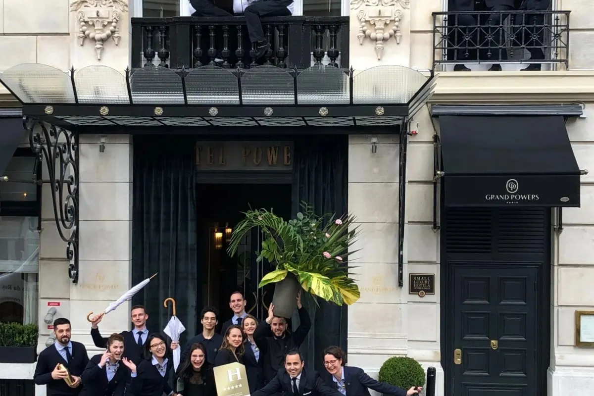 Grand Powers Paris hotel façade entrance with canopy and staff posing outside