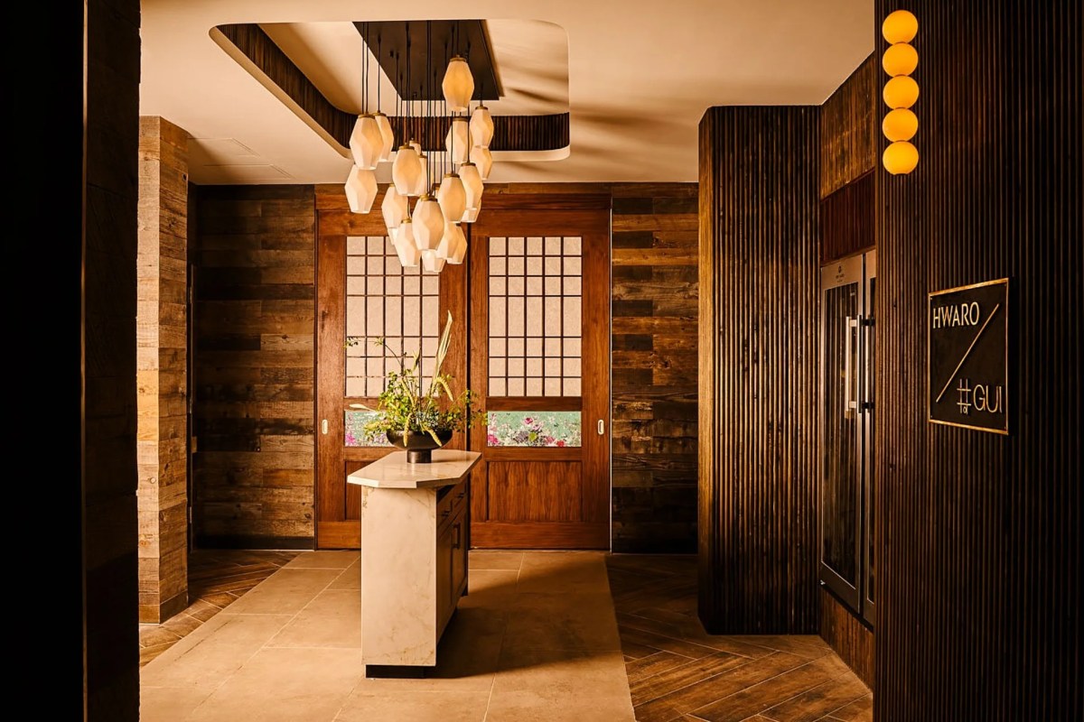 Entrance area with wooden sliding doors, pendant lights, marble console table with flowers, Hwaro/Gui signage