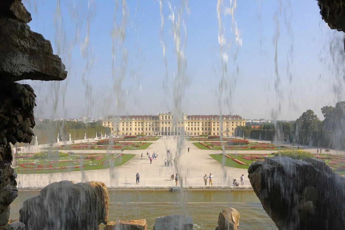 Schönbrunn Palace seen across the gardens through the cascade of the Neptune Fountain, Vienna
