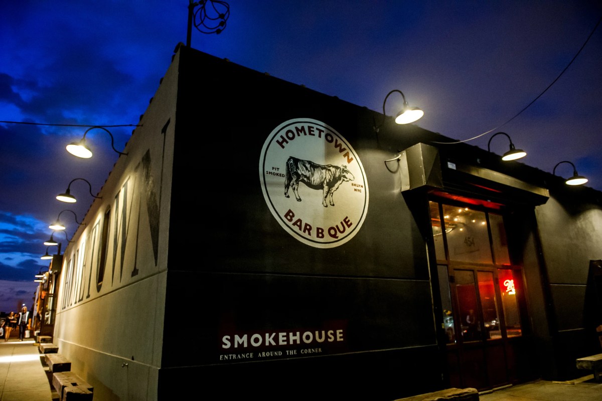 Exterior of Hometown Bar-B-Que smokehouse at dusk, lit signage and entrance
