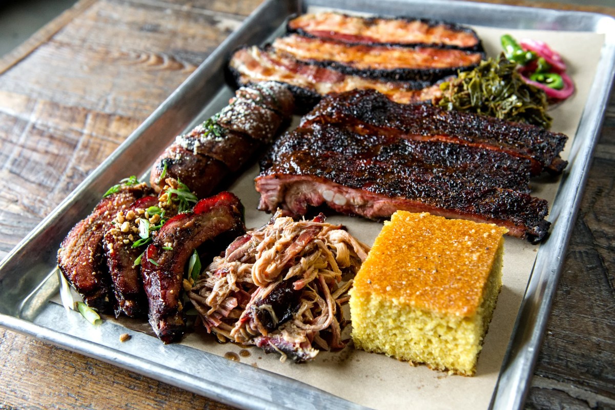 Barbecue platter with ribs, brisket, pulled pork, bacon, cornbread and greens