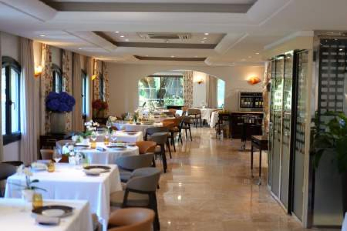 Elegant hotel dining room with set tables, wine display and garden view window