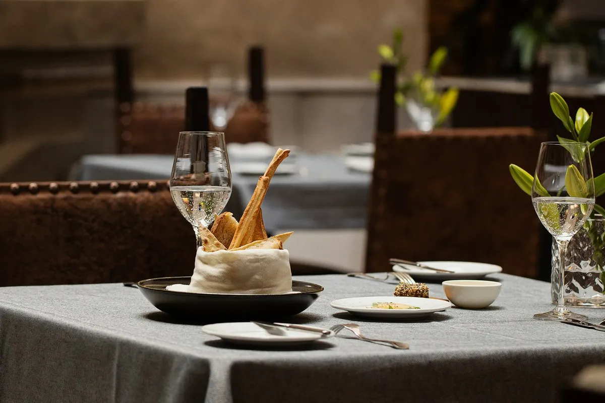 Restaurant table set with bread, wine glasses and fine dining plates