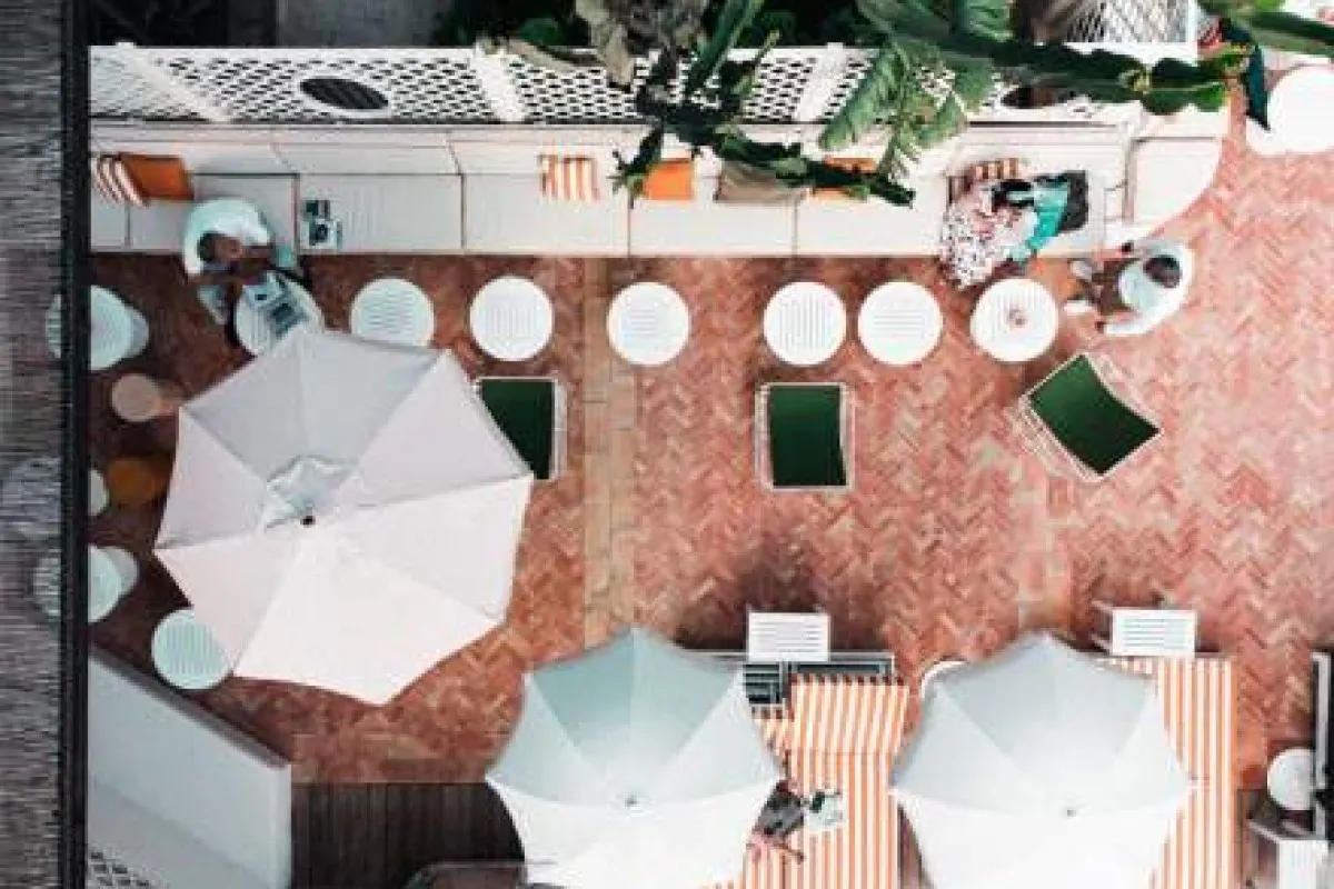 Aerial view of hotel terrace with umbrellas, loungers and herringbone-tiled floor
