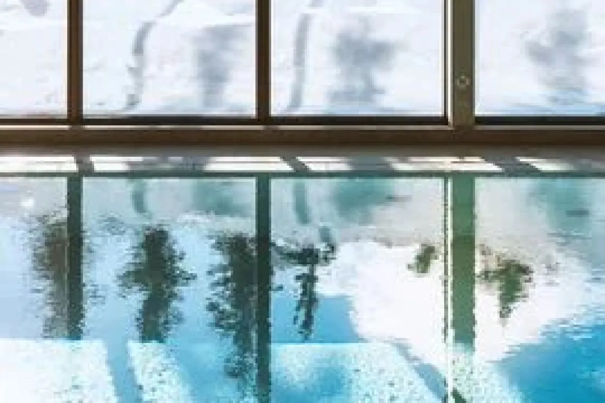 Indoor pool with window view of snowy mountain, hotel spa area