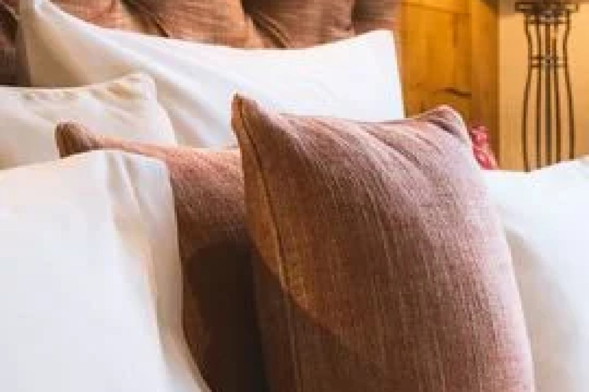 Close-up of bed pillows in brown and white tones, hotel room setting