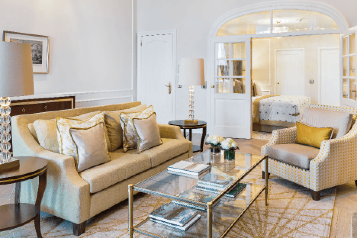 Hotel suite living room with sofa, armchair and glass coffee table