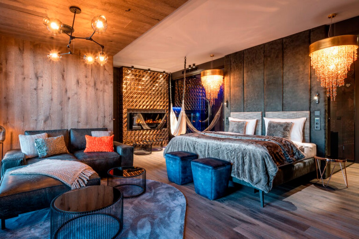 Modern guest suite with fireplace, hanging hammock chair and stylish bed