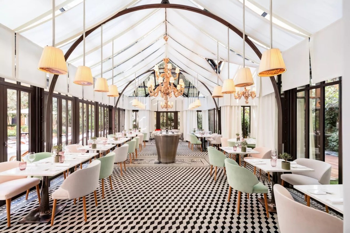 Elegant glass-roofed dining room with pastel chairs and geometric tiled floor