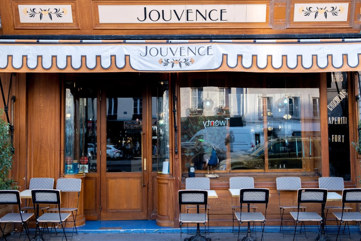 Jouvence restaurant exterior with wooden facade, awning, outdoor tables and chairs
