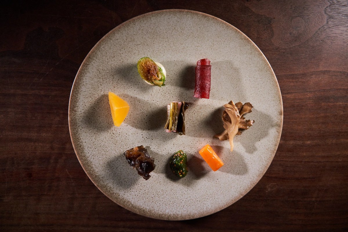 Tasting plate with assorted bite-sized dishes arranged on a round plate