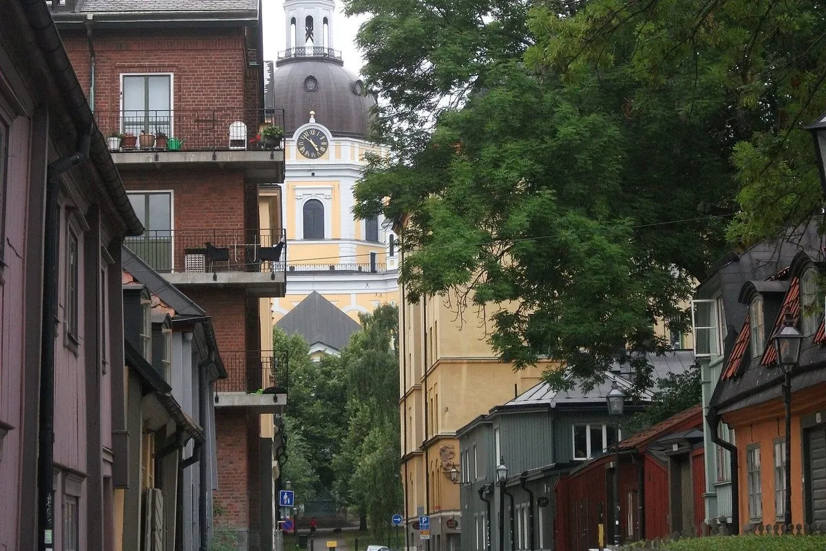 The yellow tower and dome of Katarina Church rising above the houses and trees of Mäster Mikaels gata on Södermalm, Stockholm