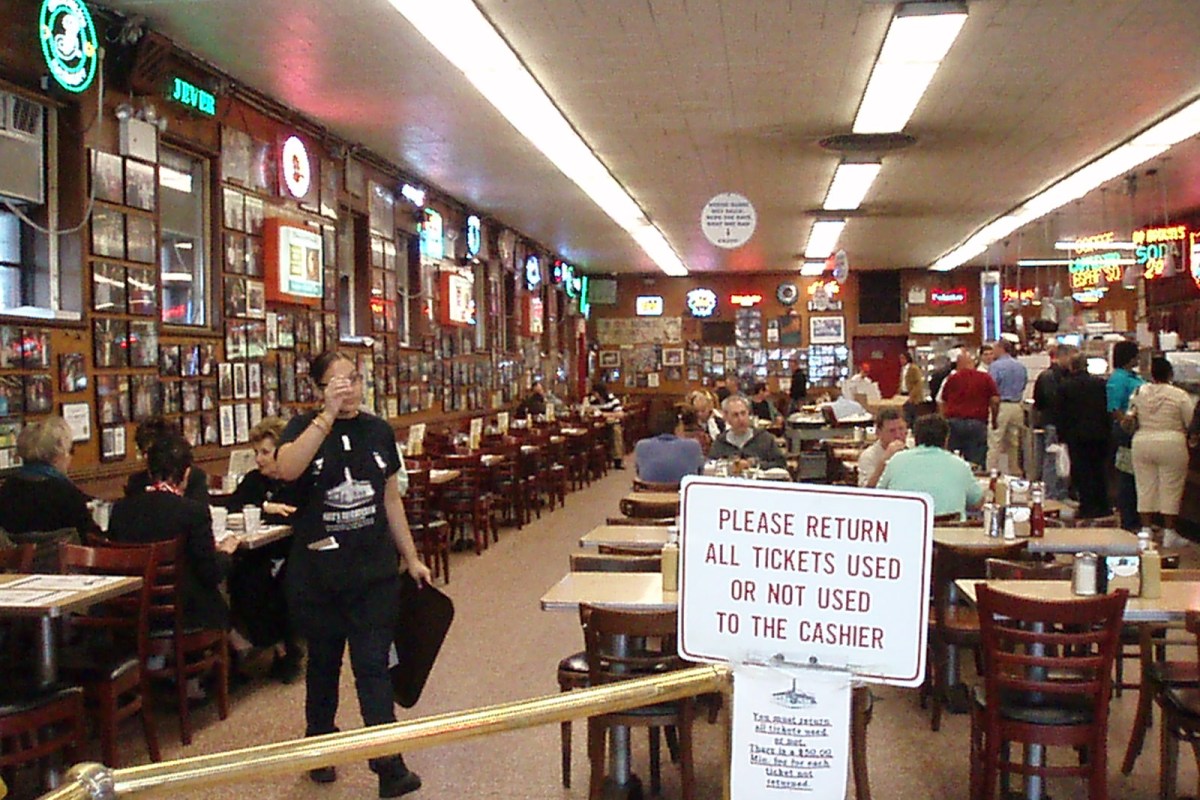 Interior dining room with tables, chairs, and wall photos at Katz's Deli