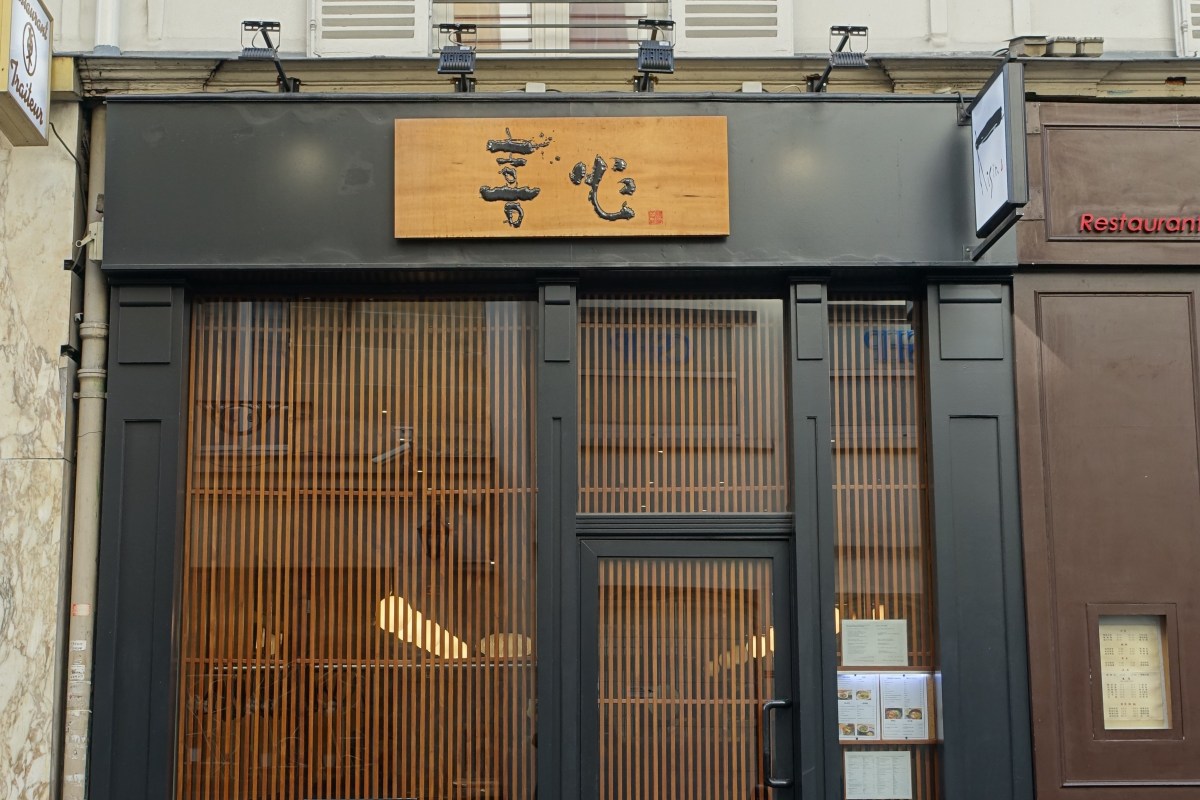 Exterior storefront of Kisin restaurant with wooden sign and slatted wood facade on Rue de Ponthieu, Paris