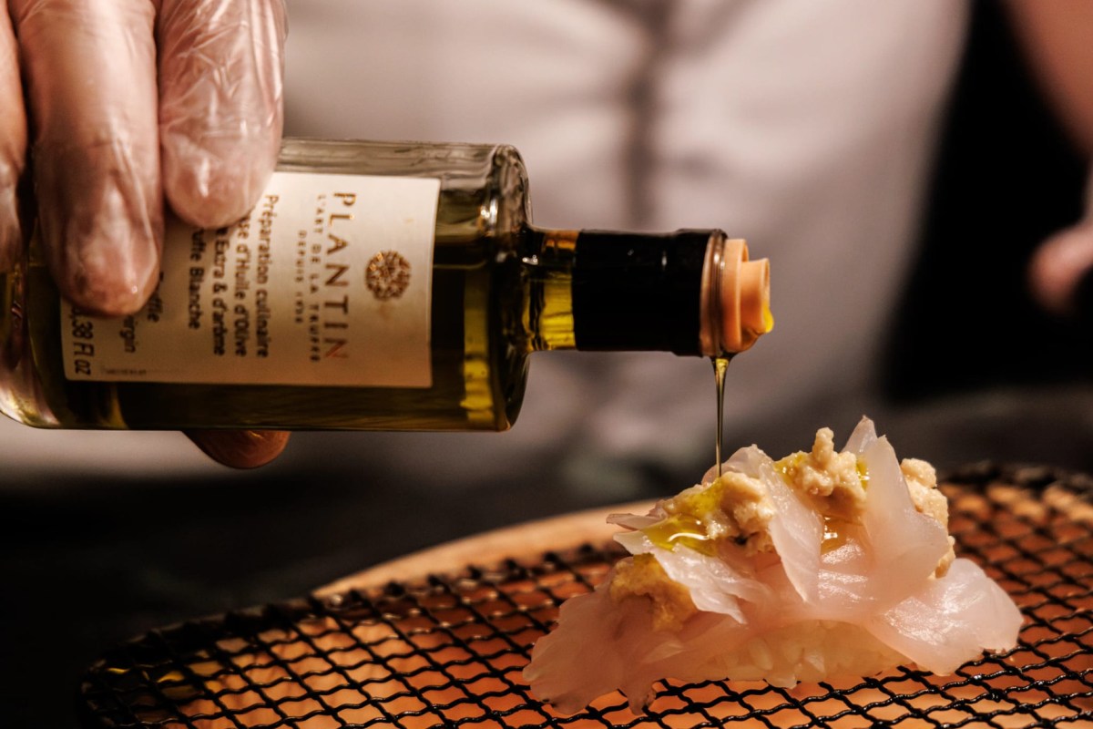 Chef drizzling truffle olive oil over a delicate fish dish at the restaurant