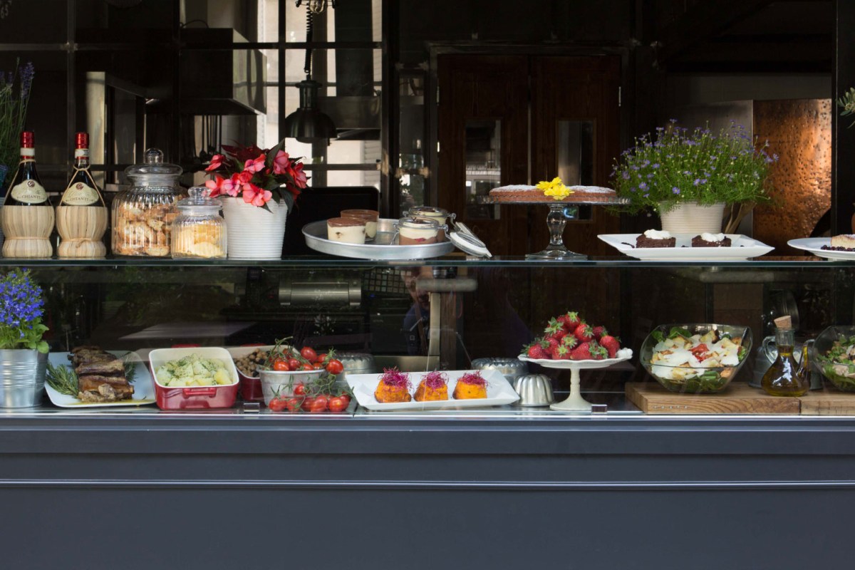 Deli-style display counter with salads, cheeses, desserts and fresh produce