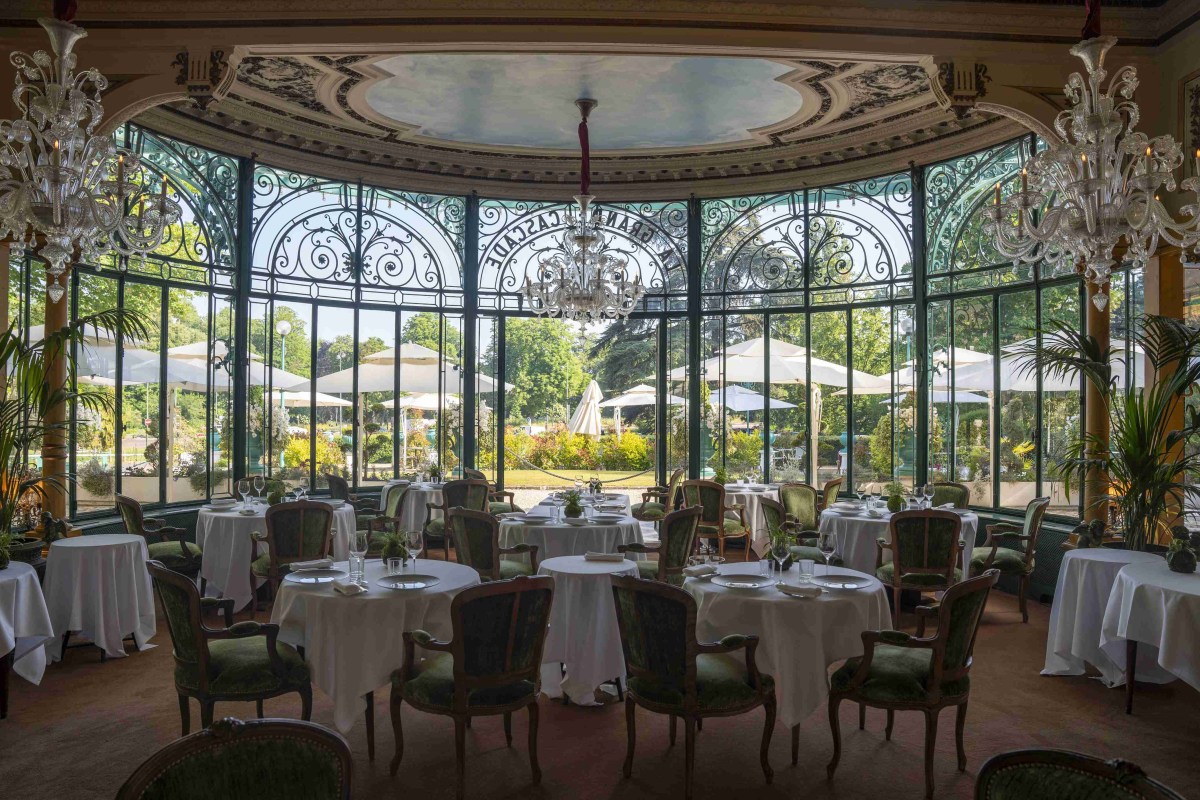 Elegant dining room with glass veranda windows overlooking the terrace and garden, crystal chandeliers.