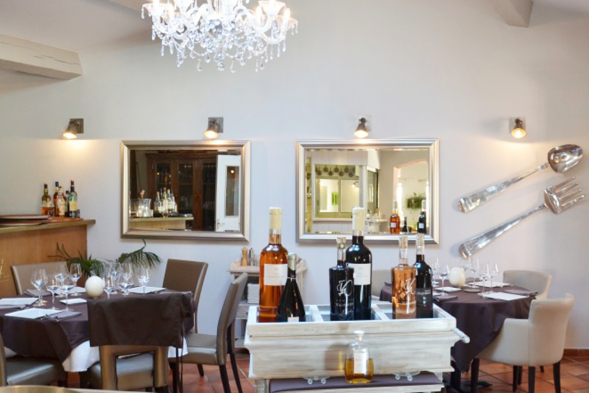 Elegant dining room interior with chandelier, mirrors, set tables and wine bottles