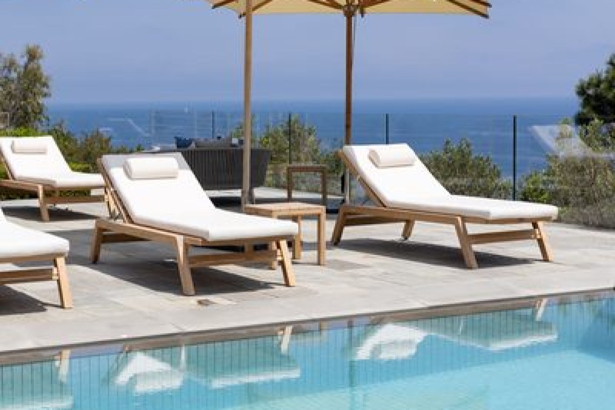 Poolside loungers with umbrella overlooking the sea