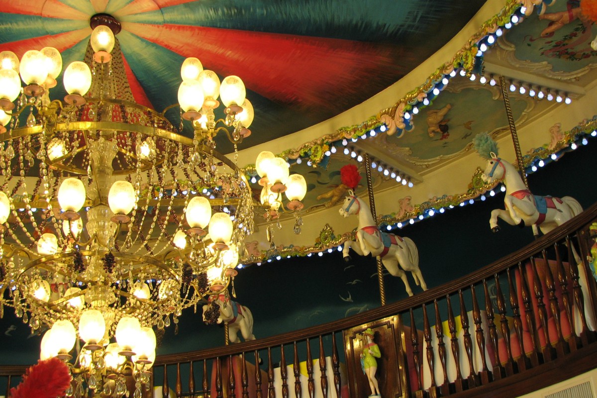 Interior of La Rotonde restaurant at Hotel Negresco, Nice, with crystal chandelier and carousel ceiling decor.