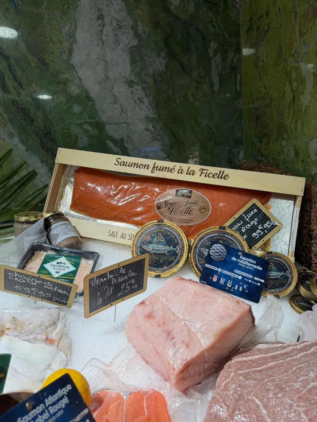 Smoked salmon and tins of caviar on ice with labels at La Sirène in Antibes
