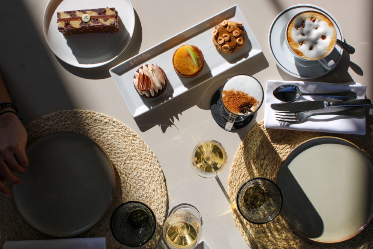 Overhead view of a laid table with pastries, cappuccino, and glasses of champagne