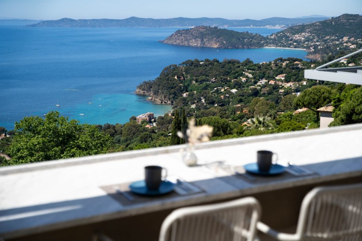 Terrace table setting overlooking the coastal bay and hills