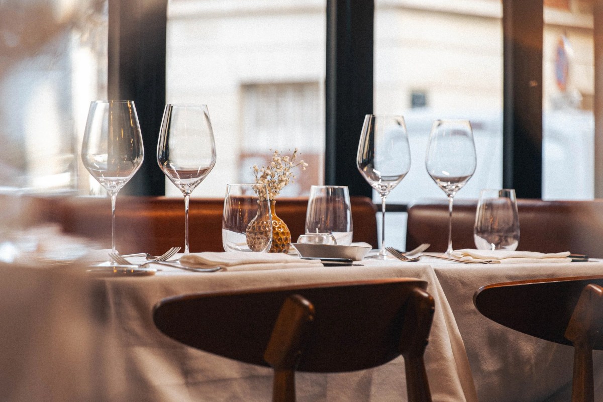 Dining room view with laid tables, wine glasses and window overlooking the street