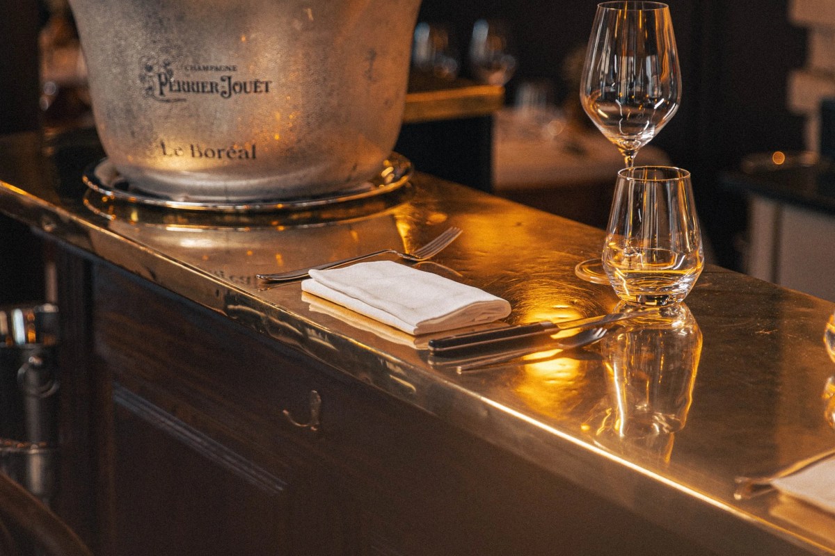 Gold-toned bar counter with a champagne bucket labeled Le Boréal and wine glasses