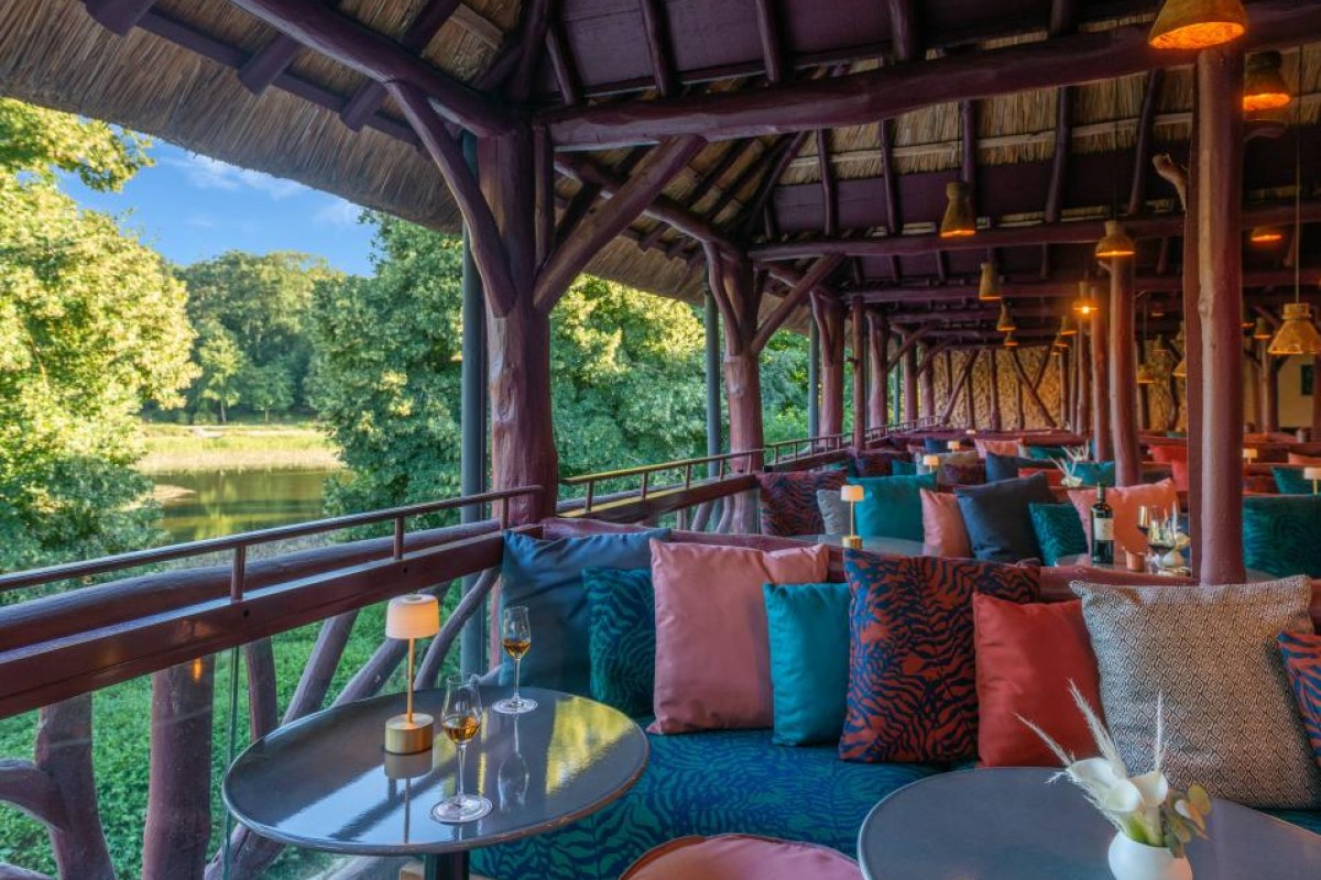 Colorful lounge bar area on a covered terrace with river view and rustic wooden beams
