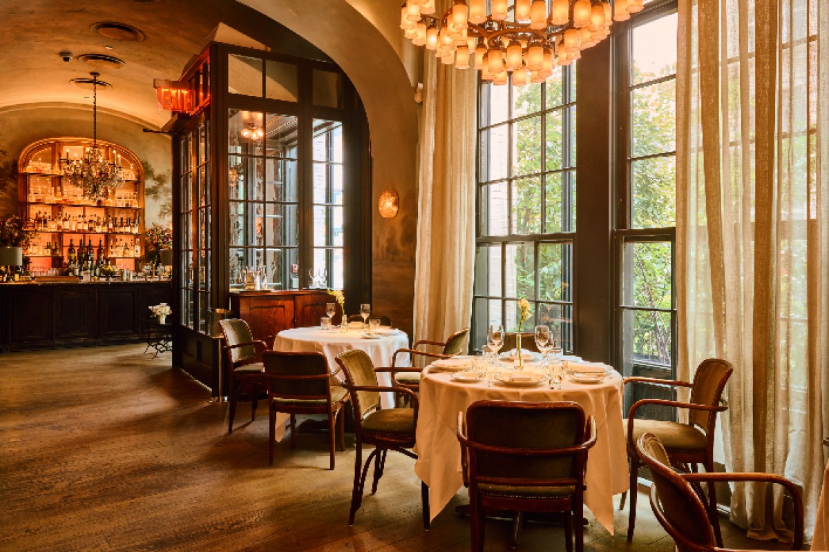 Le Coucou dining room view with bar in background, set tables and large windows