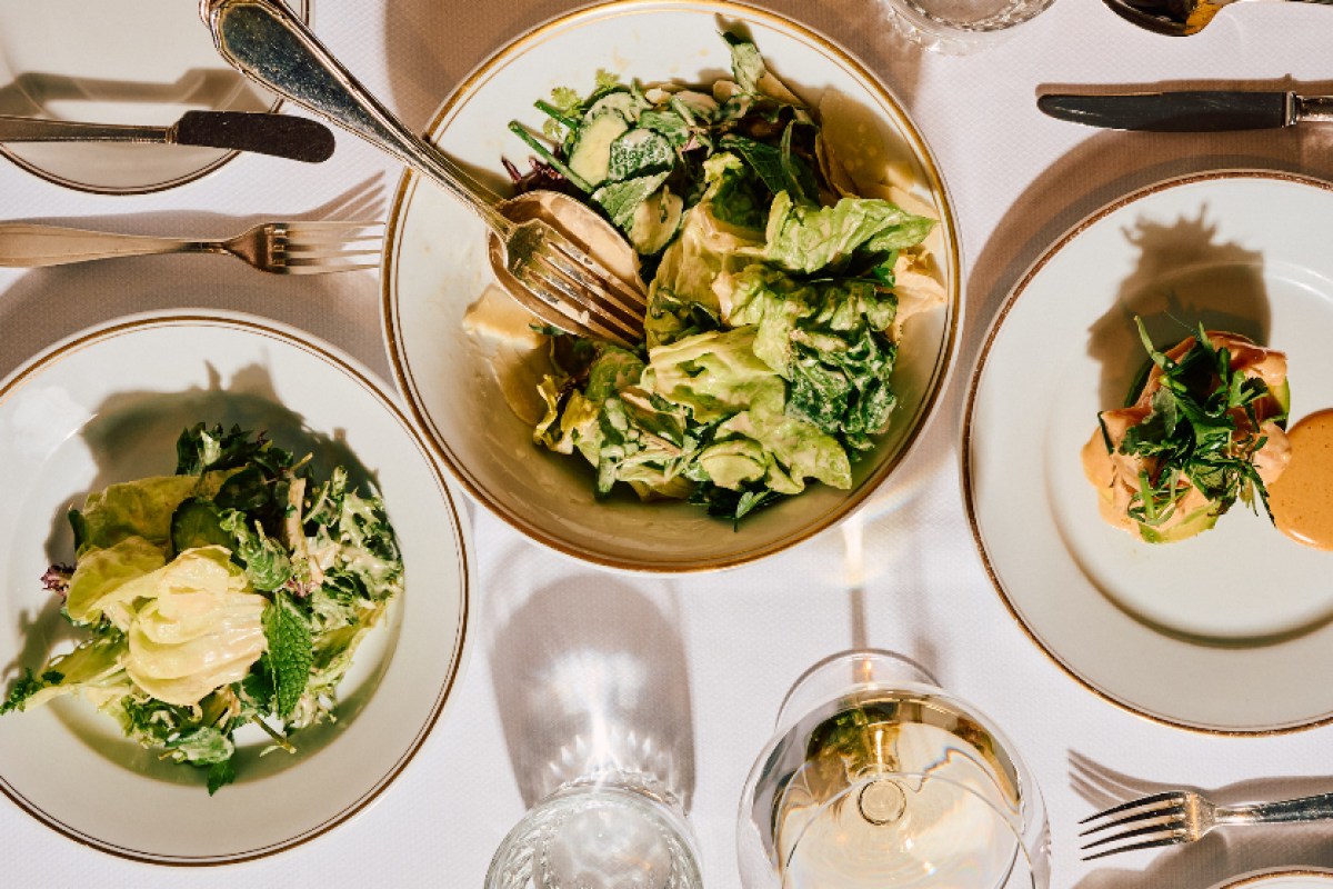 Overhead view of salads and appetizers on a table at Le Coucou