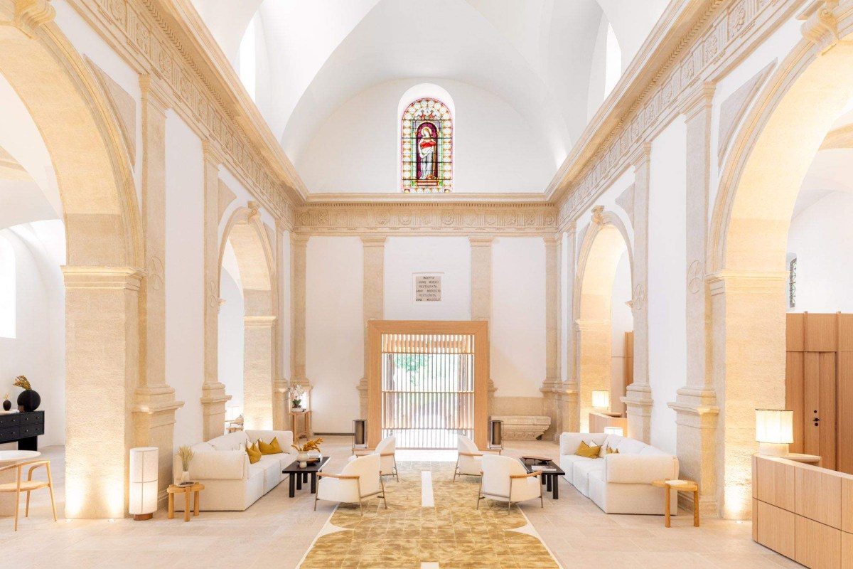 Former chapel interior lounge with arches, stained glass window and seating