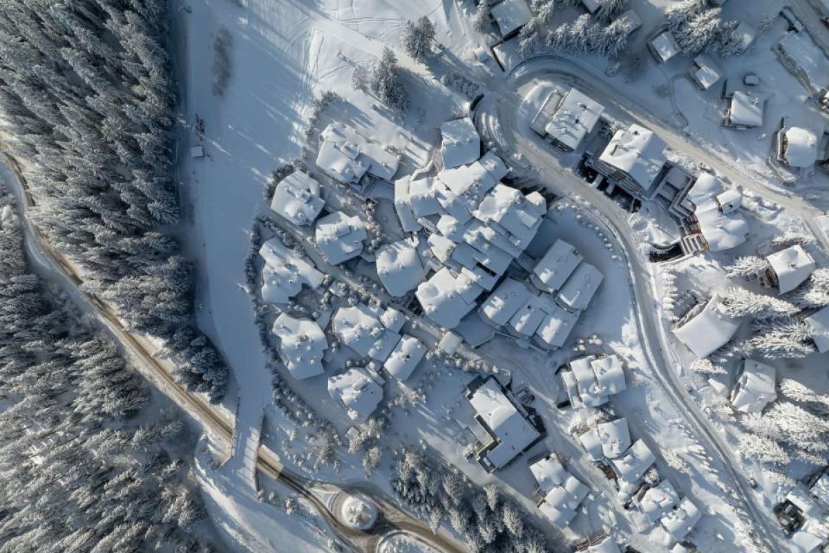 Aerial winter view of Le K2 Palace hotel complex and surrounding snow-covered village in Courchevel
