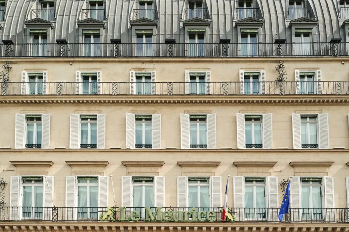 Close-up of Le Meurice's classic Parisian façade with shuttered windows, balconies, and hotel signage.