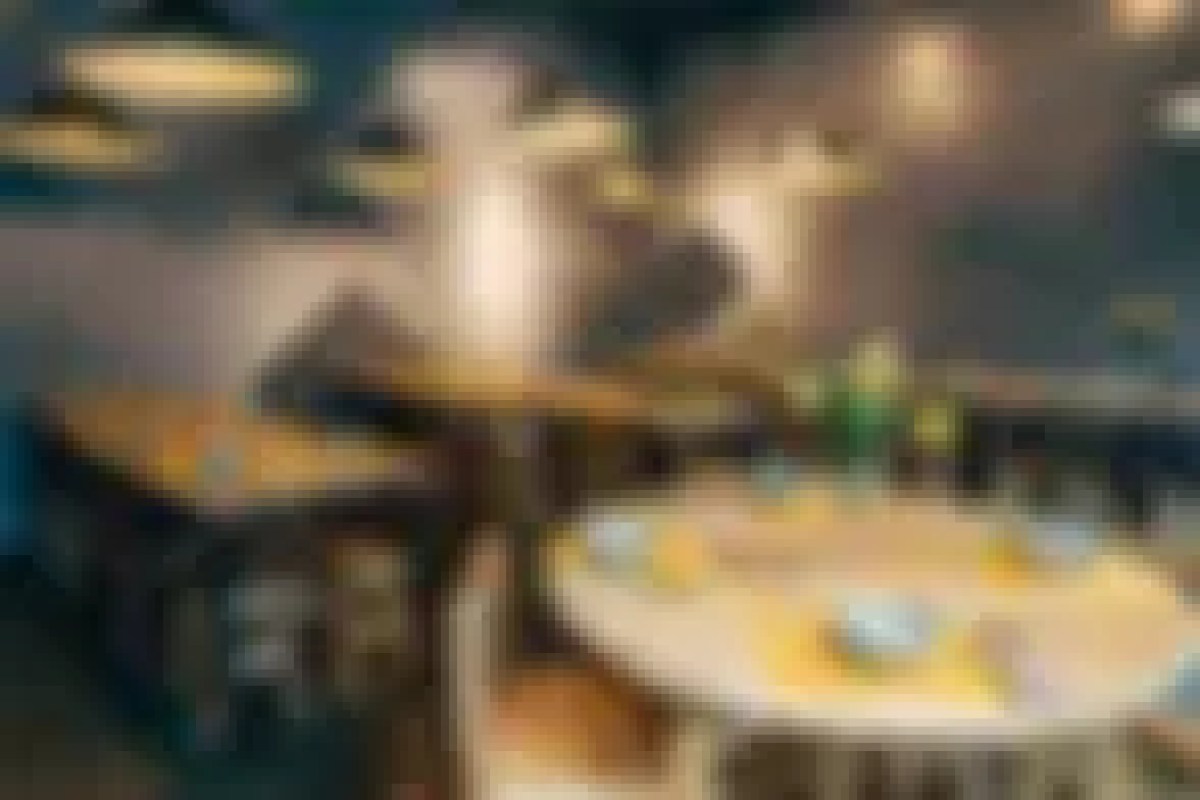 Blurry interior view of the dining room with tables, bowls, and pendant lighting
