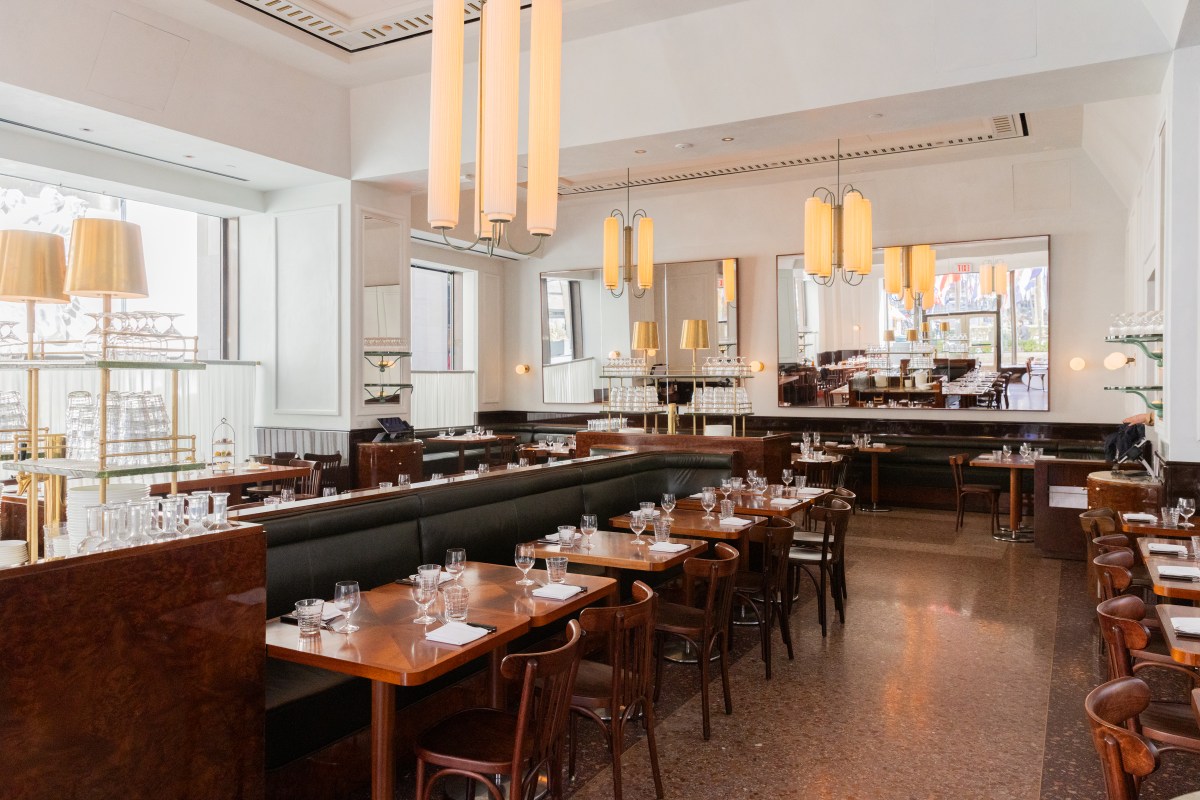 Restaurant dining room with wooden tables, leather booths, mirrors and hanging light fixtures