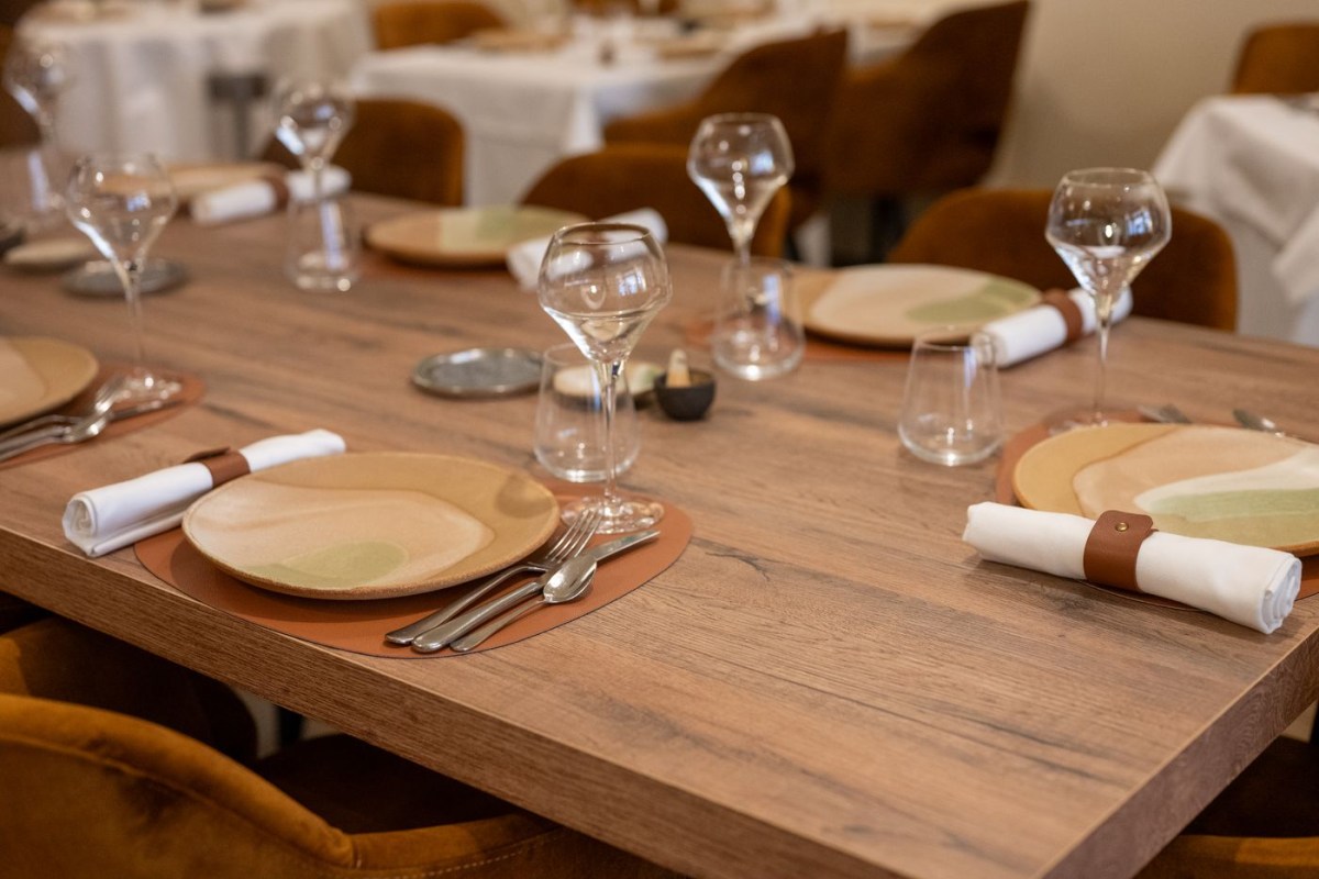 Laid table with plates, wine glasses, and cutlery in the dining room