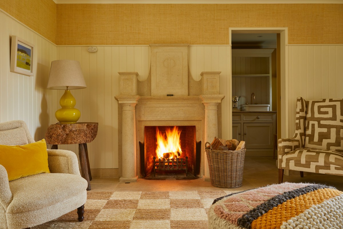 Cozy lounge with stone fireplace, armchairs, and patterned rug