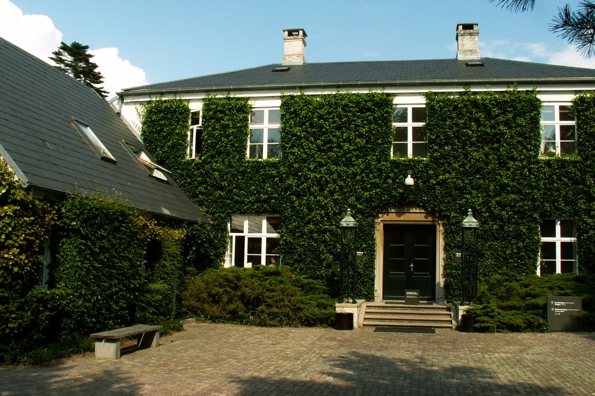 Close-up of the ivy-covered entrance facade of the museum with lanterns flanking the door