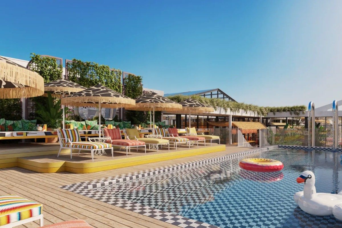 Rooftop pool and terrace with lounge chairs, umbrellas, and hotel building visible in background