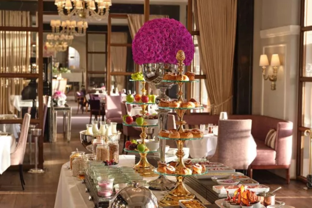 Dining room with a dessert buffet display of pastries and fruit on tiered stands