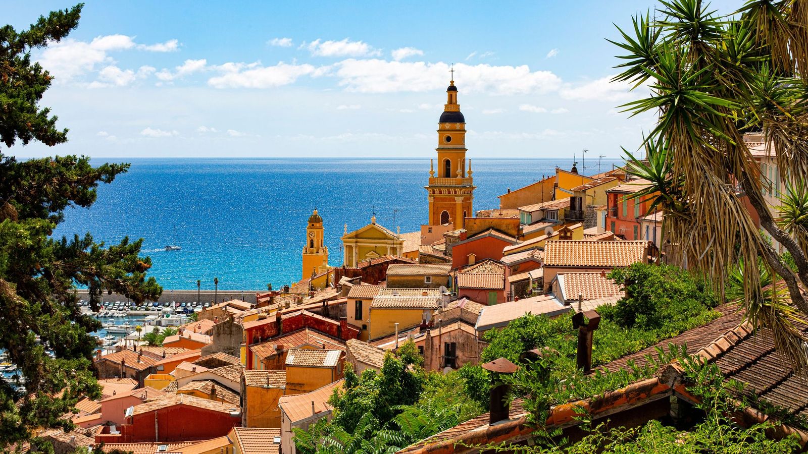 The old town of Menton climbing to the bell tower of the Basilica of Saint-Michel, with the sea beyond