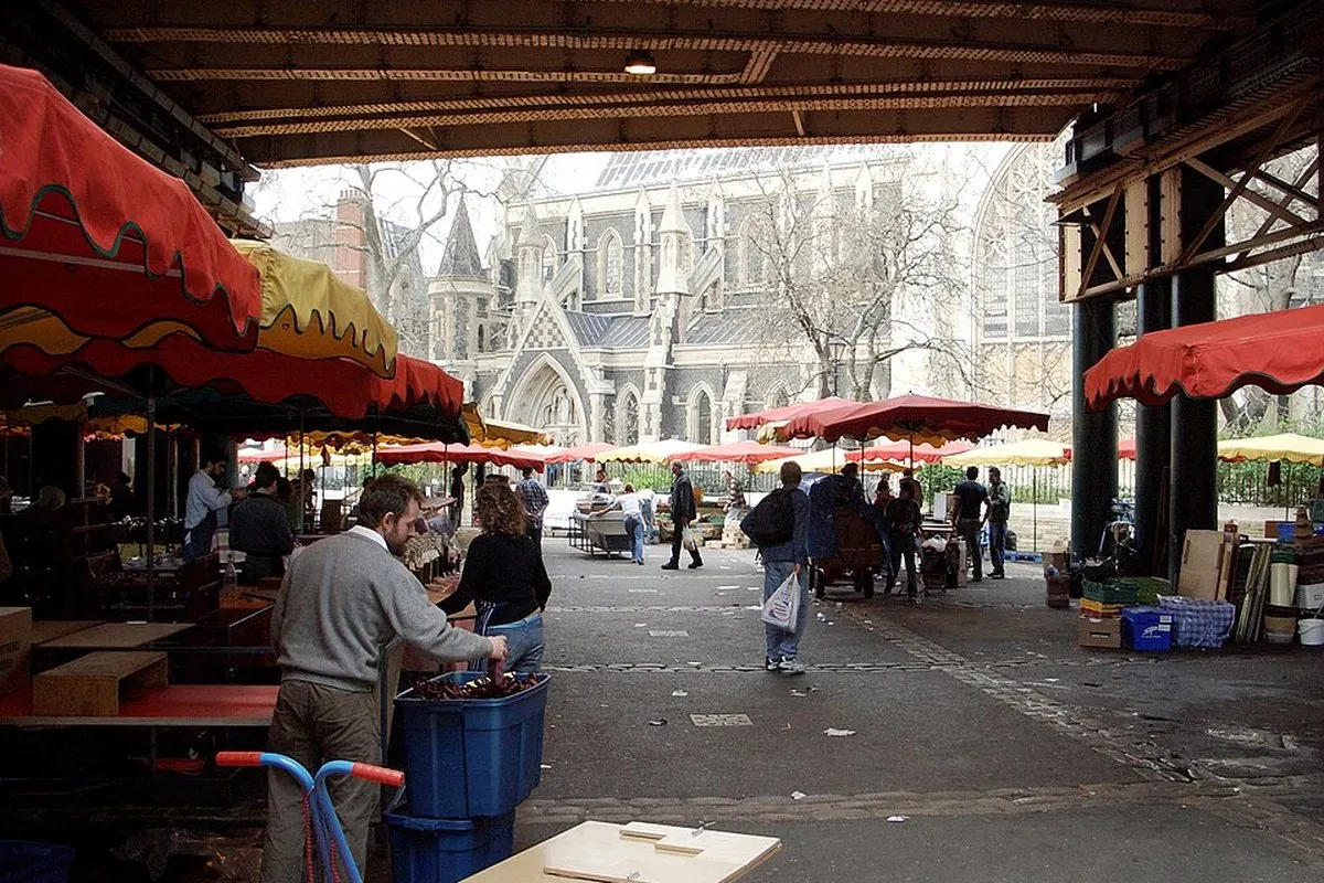 Stalls under the iron roof of Borough Market, with Southwark Cathedral beyond