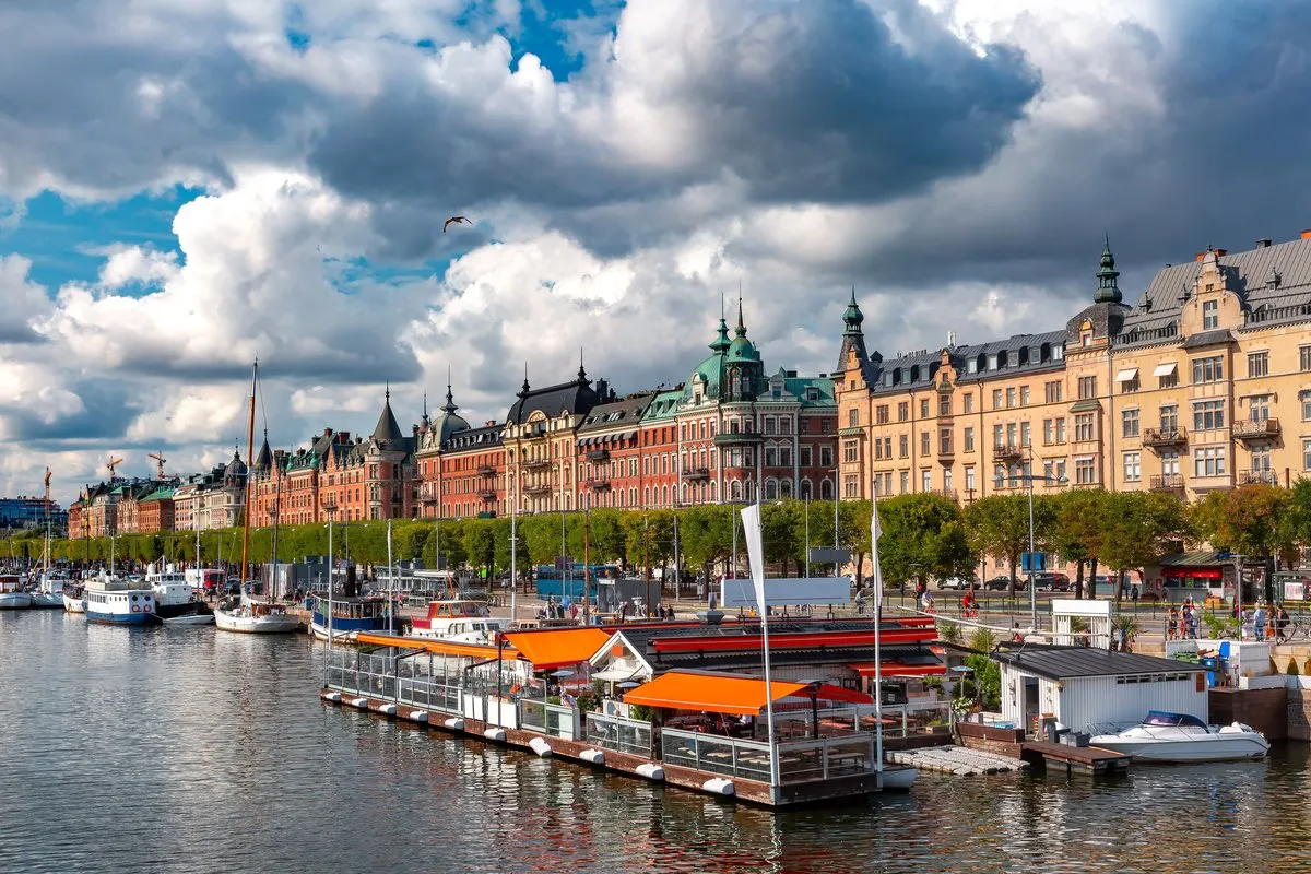 The stone buildings of Strandvägen with a tower and boats along the quay in Östermalm in Stockholm